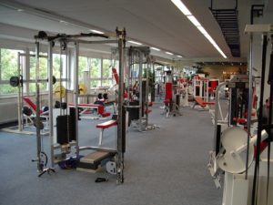 Fitnessstudio einer Fitnesskette, viele Maschinen mit rotem Bezug, Multipresse, Latturm etc.